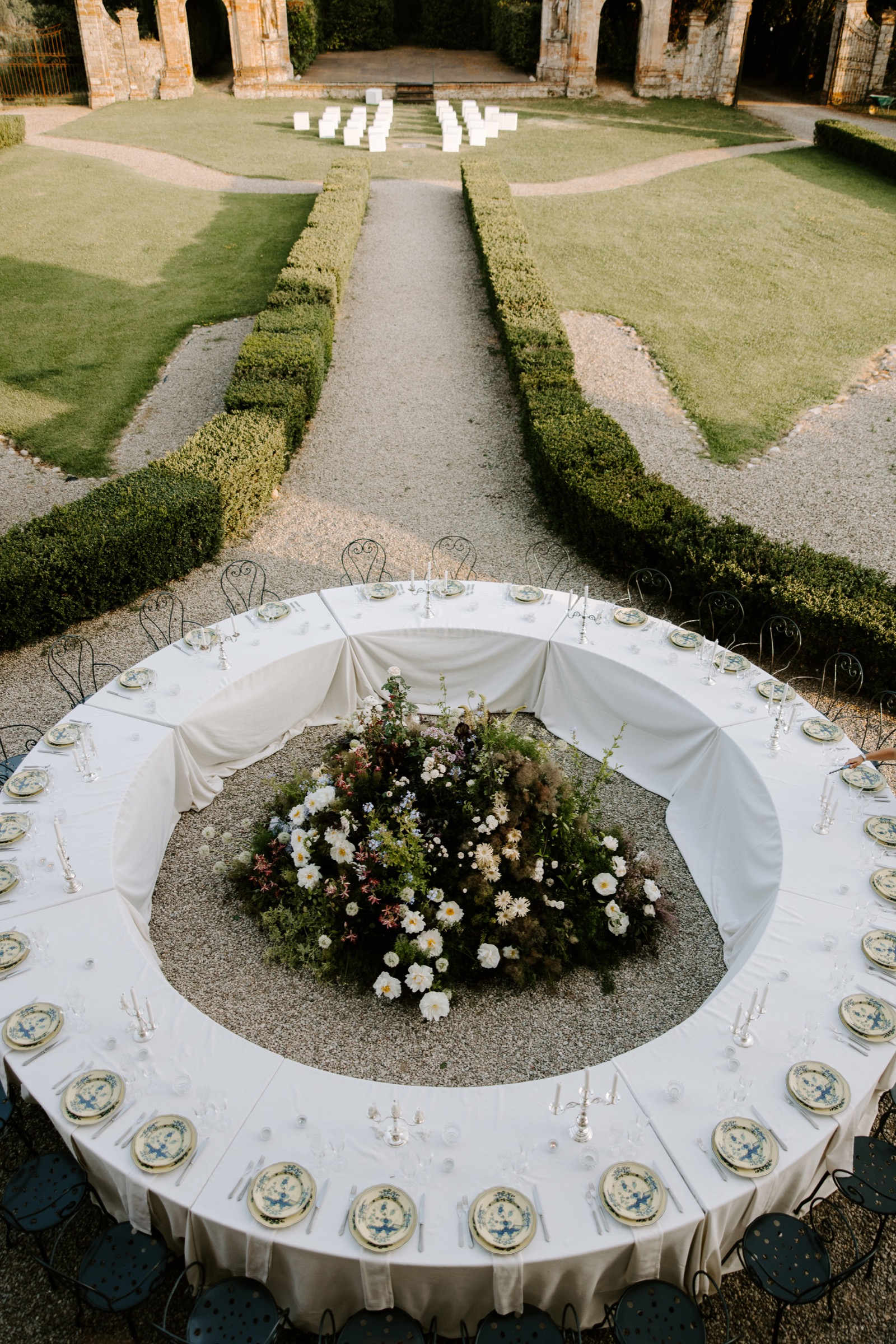 Circular wedding reception table with flowers in an Italian garden