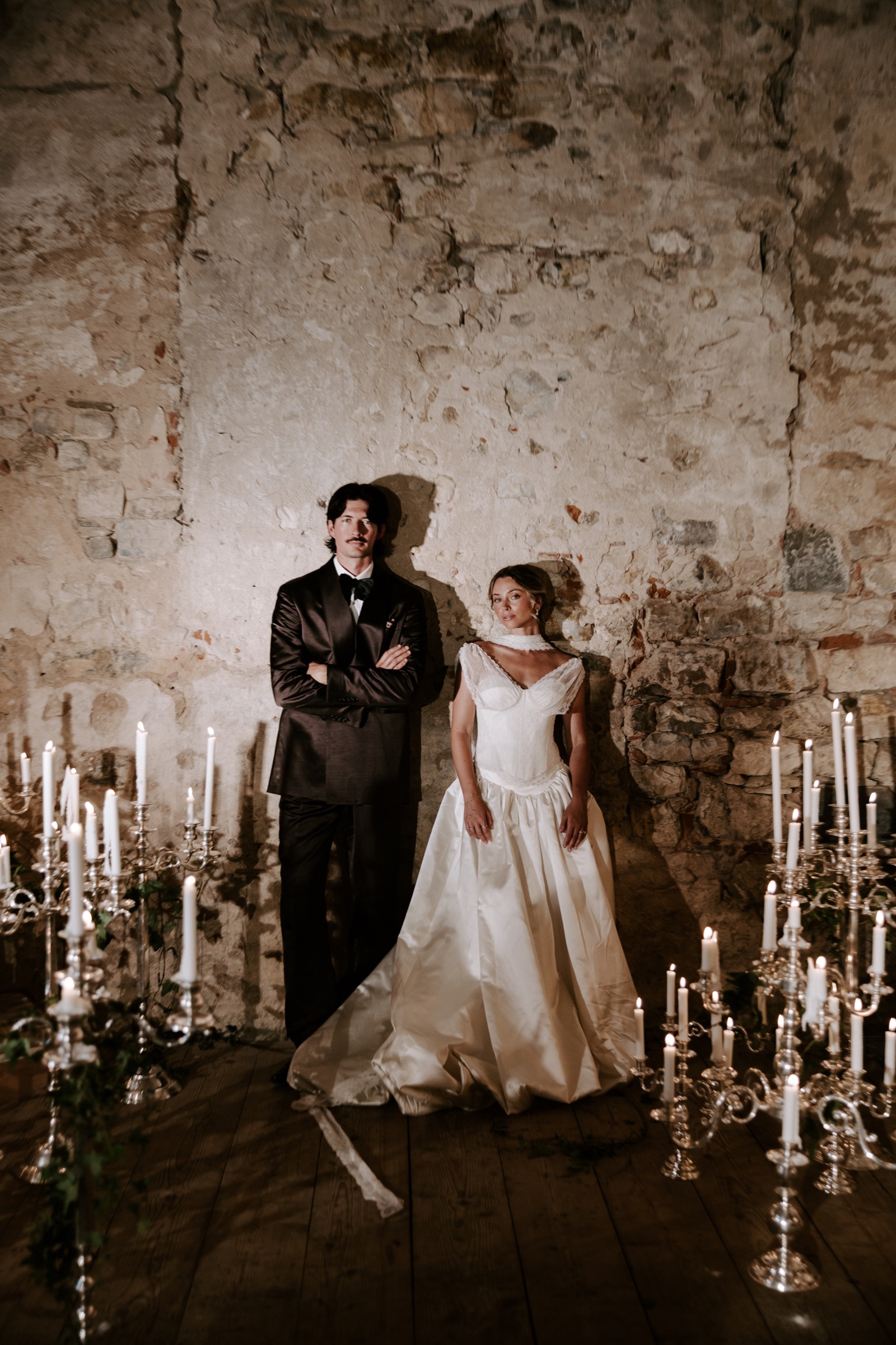 Bride and groom standing among candlelit candelabras in an Italian villa