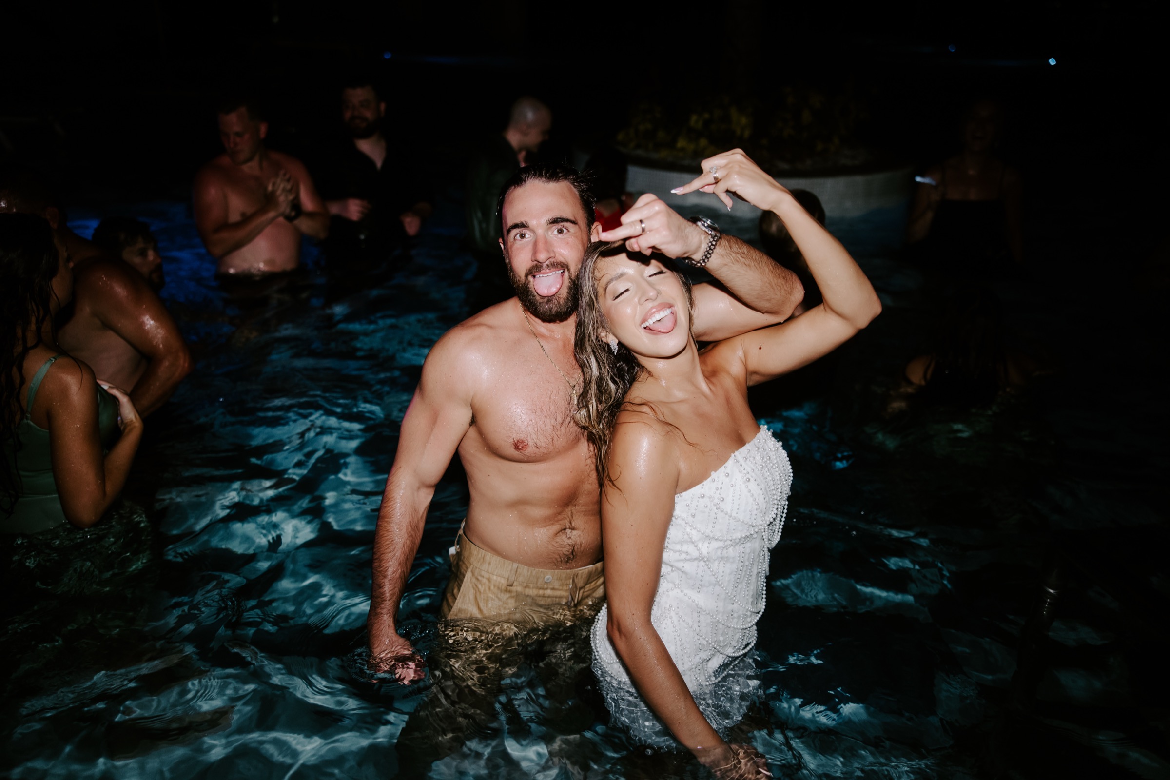 Ashley and Sean celebrating in the pool at their wedding after-party