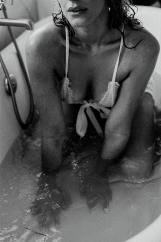 Black-and-white boudoir portrait in a bathtub