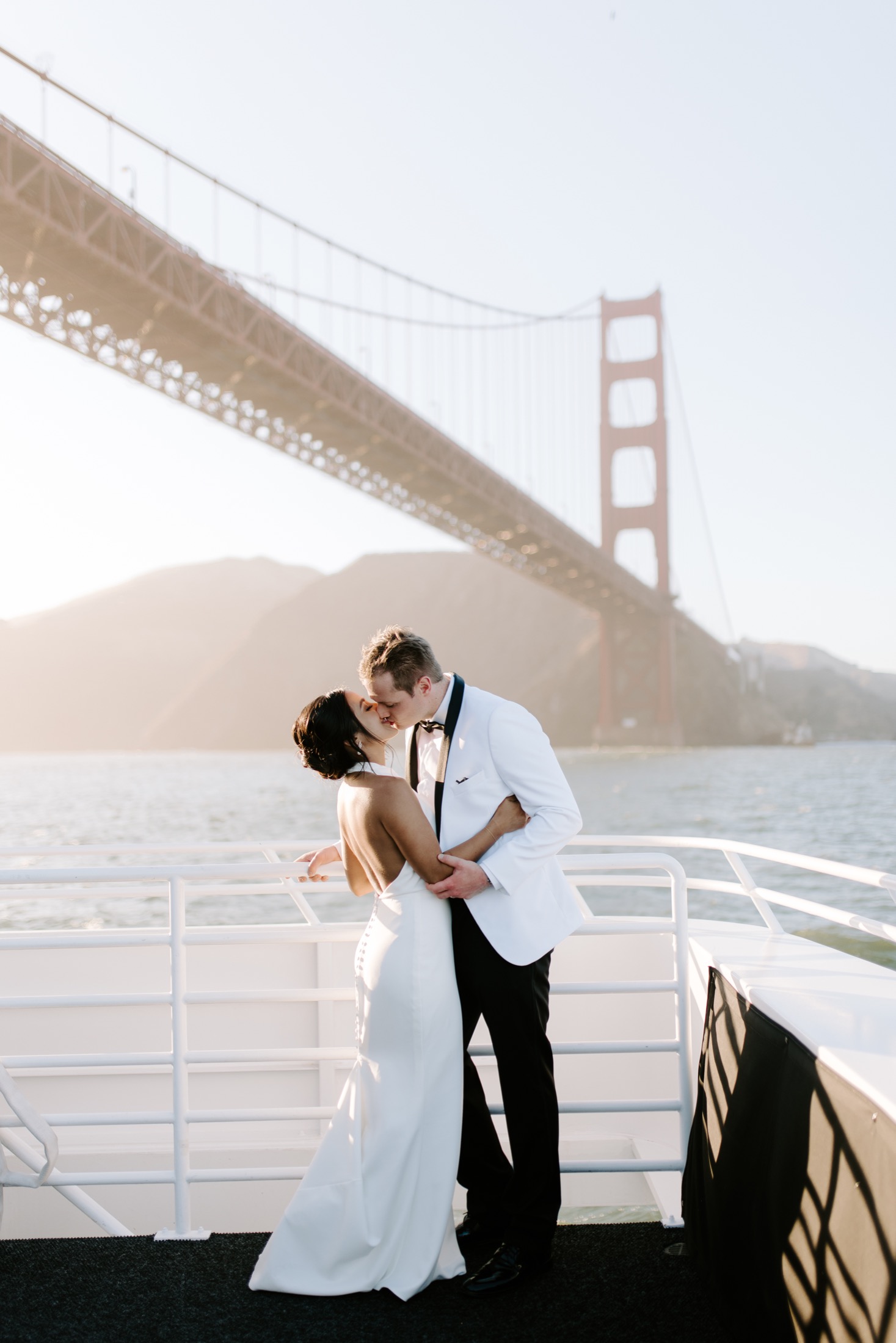 Newlyweds on a boat beneath the Golden Gate Bridge