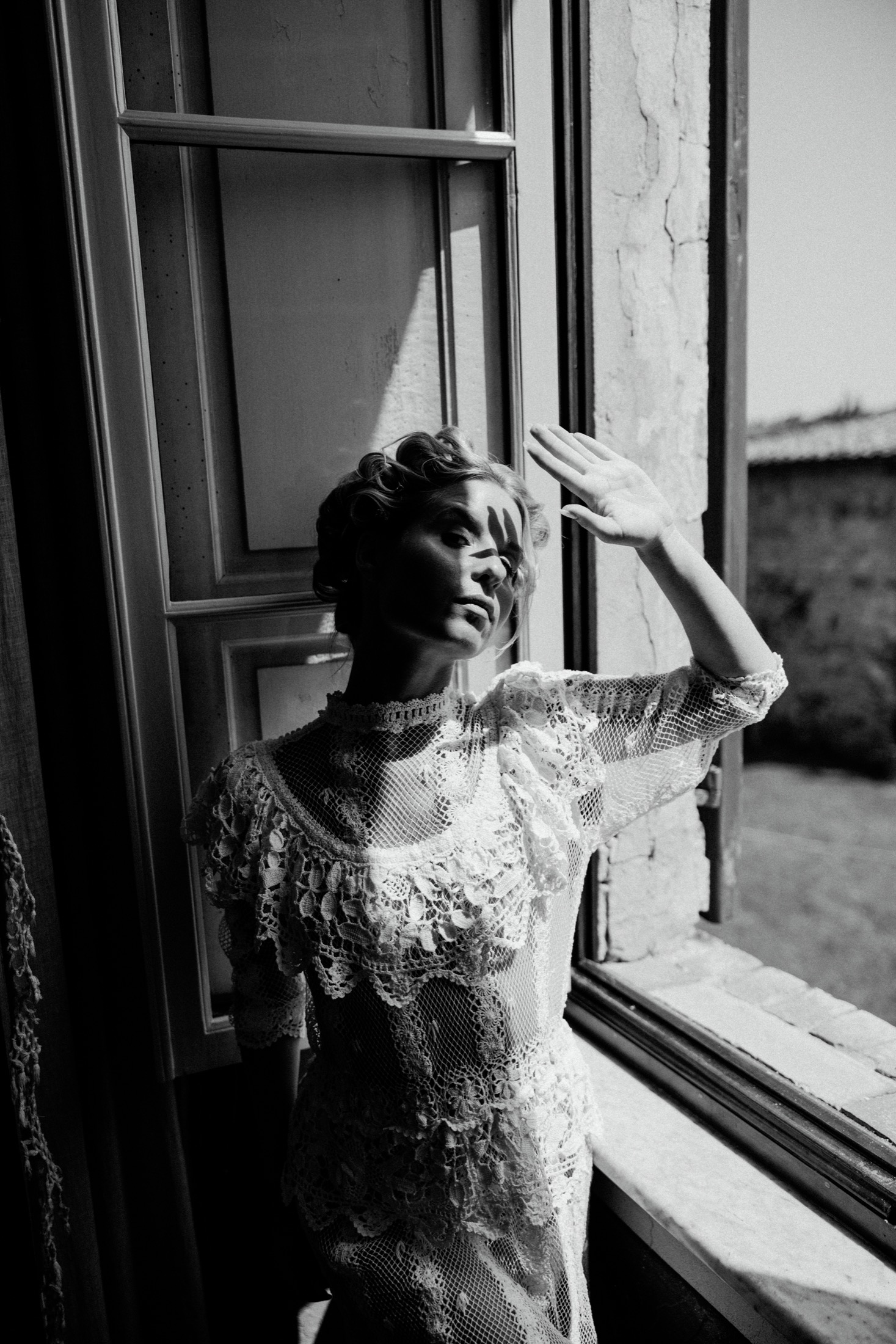 Black-and-white bridal portrait beside an Italian villa window