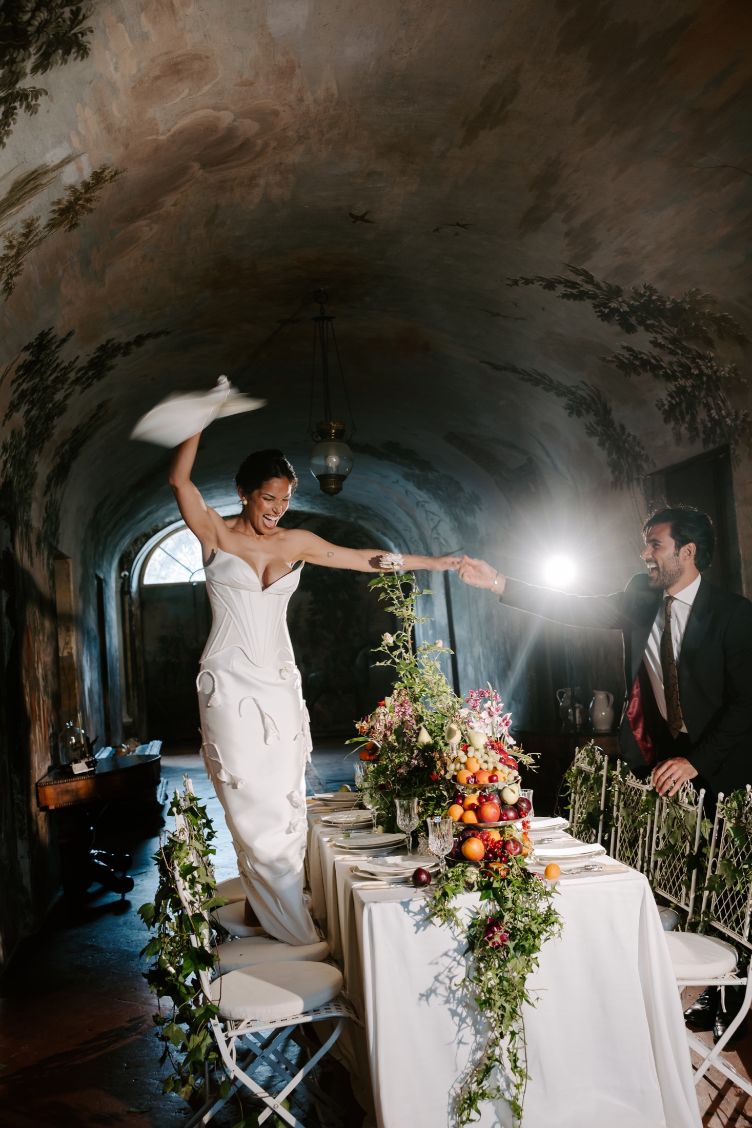 Bride and groom celebrating at a floral reception table in Italy