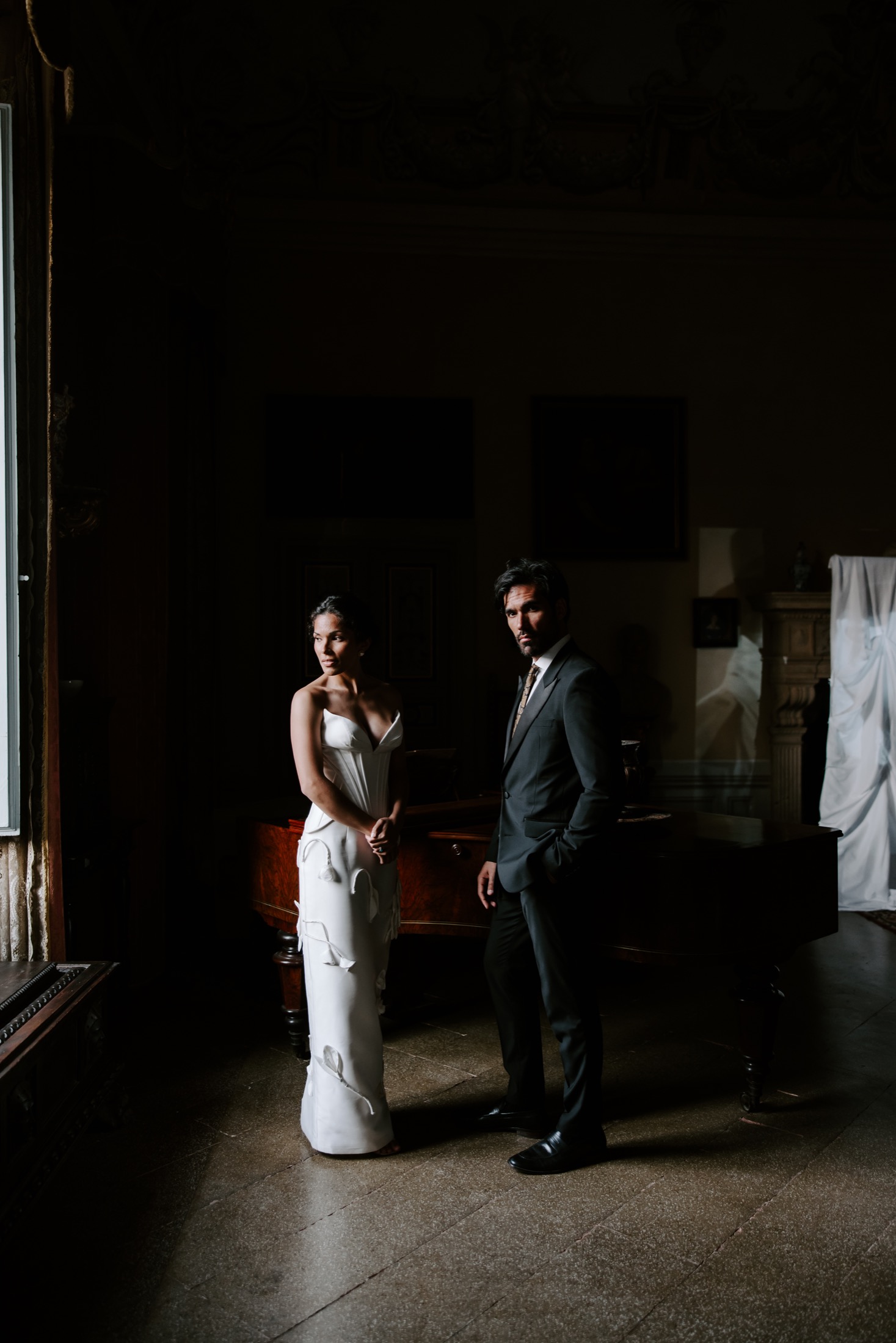 Couple in a dramatic window-lit wedding portrait in Italy