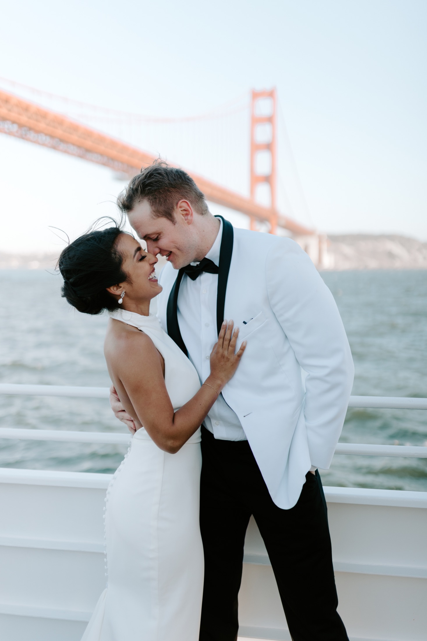 Newlyweds laughing on a boat near the Golden Gate Bridge