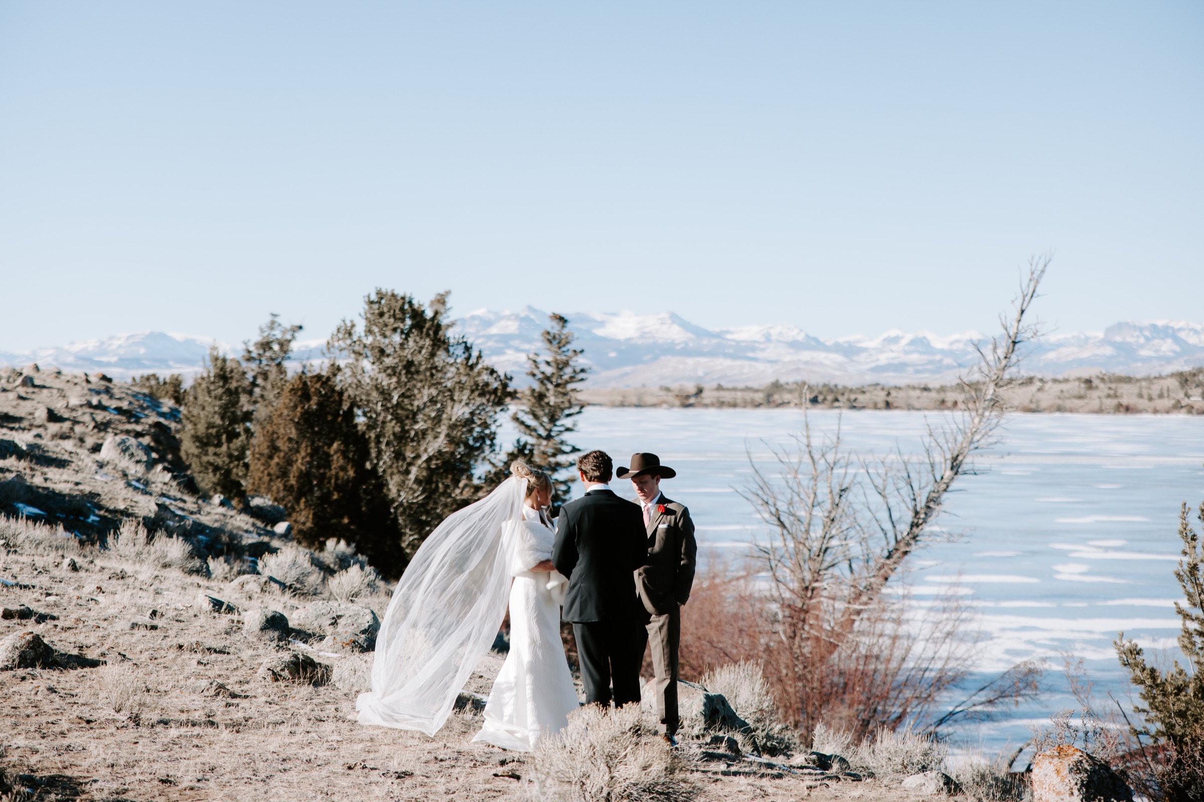 An intimate wedding ceremony overlooking a lake and snowy mountains