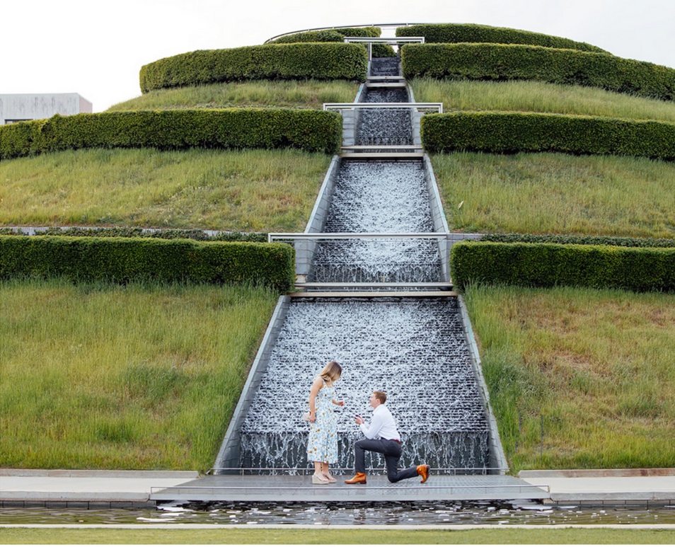 A proposal in front of a cascading garden fountain