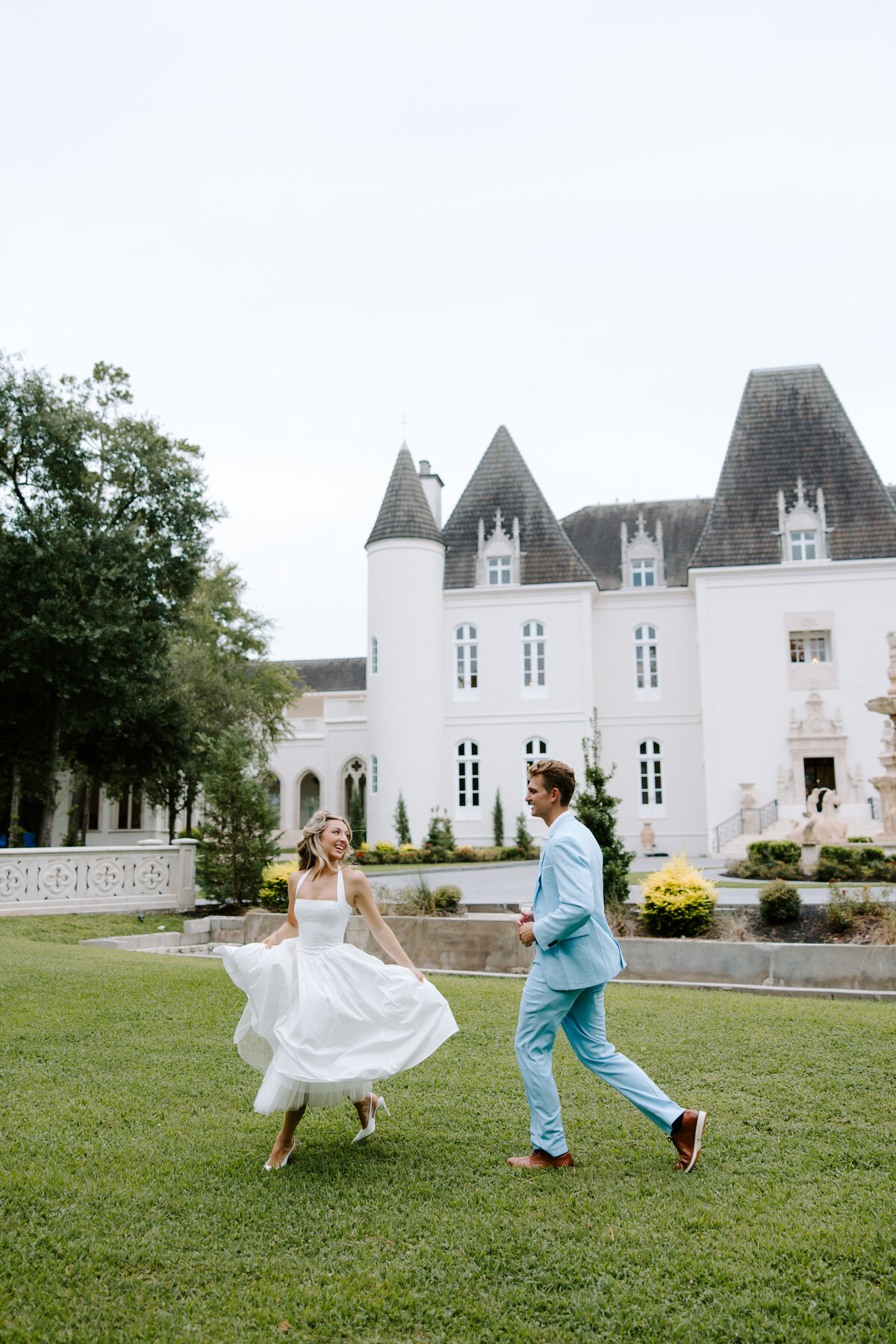 A couple laughing together outside a chateau