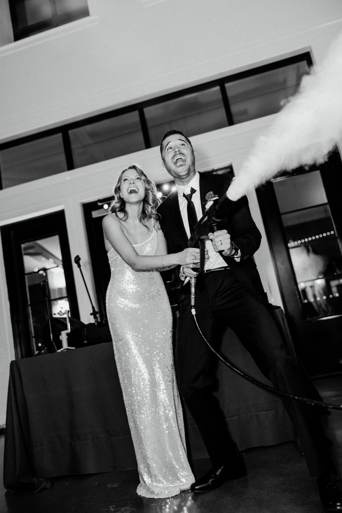 Newlyweds laughing together with a celebration cannon